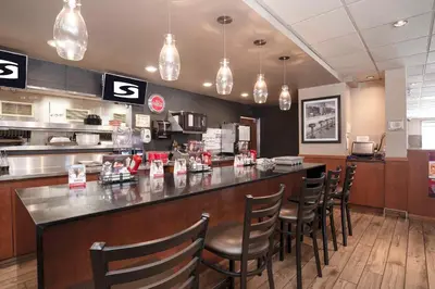 a bar in a restaurant with chairs at a counter at Sandman Hotel Cranbrook in Cranbrook