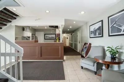 a large living room with a staircase and a kitchen at Sandman Inn Kamloops in Kamloops