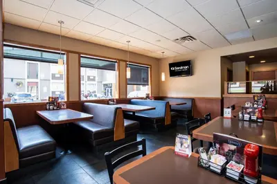 a restaurant with tables and chairs and a bar at Sandman Inn Kamloops in Kamloops