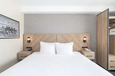 a bedroom with a white bed and two night stands at Sandman Hotel Quesnel in Quesnel