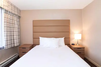 a bedroom with a large white bed with a window at Sandman Hotel Terrace in Terrace