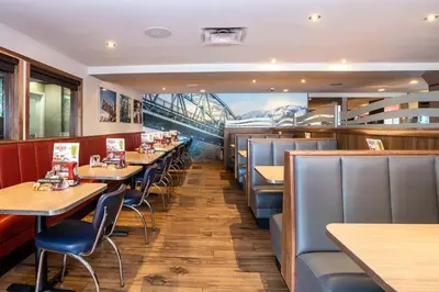 a restaurant with tables and chairs and a bridge at Sandman Hotel Terrace in Terrace