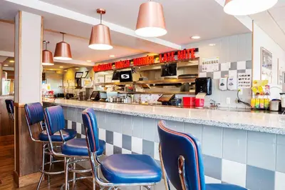 a restaurant with blue chairs and a counter at Sandman Hotel Terrace in Terrace