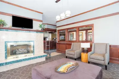 a living room with a fireplace and a tv at Sandman Hotel Terrace in Terrace