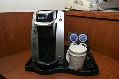 a coffee maker and a cup on a counter at Quality Hotel & Conference Centre in Peace River