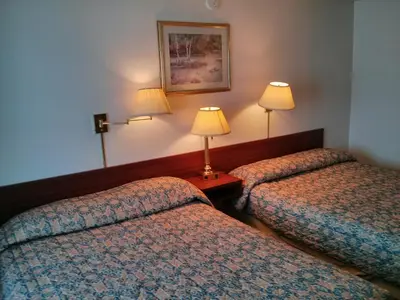 a hotel room with two beds and two lamps at Shamrock Motel in Valleyview