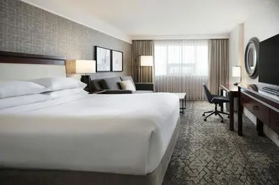 a hotel room with a large bed and a desk at Sheraton Cavalier Calgary Hotel in Calgary