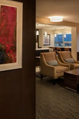 a living room with two chairs and a couch at Sheraton Cavalier Calgary Hotel in Calgary