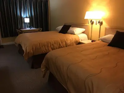 a hotel room with two beds and a window at Westwood Motel 100 Mile House in One Hundred Mile House