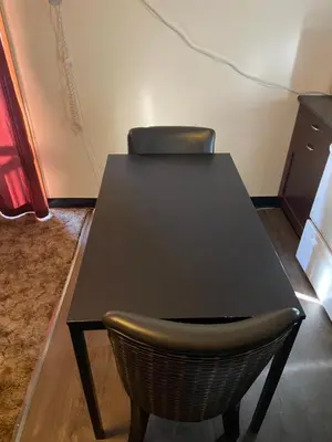 a black table and a chair in a room at Mountain View Motel in Smithers