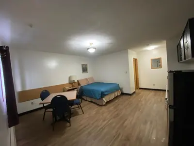 a bedroom with a bed and a desk and a table at Mountain View Motel in Smithers
