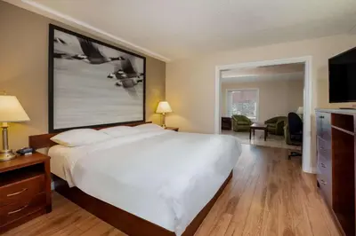 a hotel room with a large bed and a living room at Super 8 by Wyndham Smoky Lake in Smoky Lake