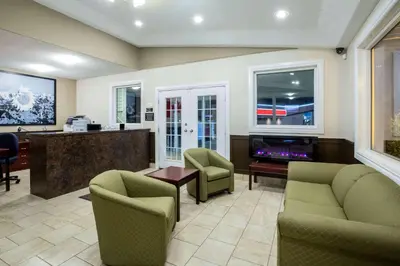a lobby with chairs and a bar in a hospital at Super 8 by Wyndham Smoky Lake in Smoky Lake