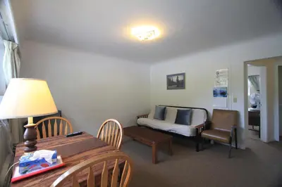 a living room with a table and a bed at Sunset Motel & Trailer Park, Incorporated in Port Alberni