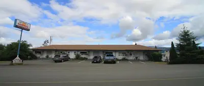 a gas station with cars parked in a parking lot at Sunset Motel & Trailer Park, Incorporated in Port Alberni