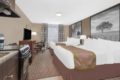 a hotel room with two beds and a flat screen tv at Super 8 by Wyndham Athabasca AB in Athabasca