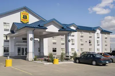 a hotel with a car parked in a parking lot at Super 8 by Wyndham Fort Saskatchewan in Fort Saskatchewan