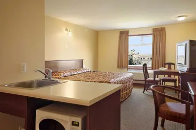a hotel room with a bed and a sink at Super 8 by Wyndham Fort Saskatchewan in Fort Saskatchewan