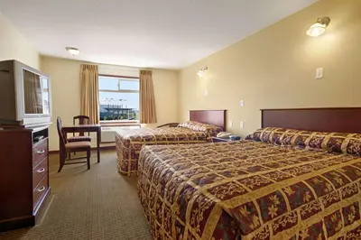 a hotel room with two beds and a television at Super 8 by Wyndham Fort Saskatchewan in Fort Saskatchewan