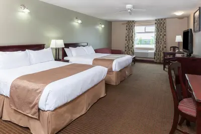 a hotel room with two beds and a television at Super 8 by Wyndham Fort Saskatchewan in Fort Saskatchewan