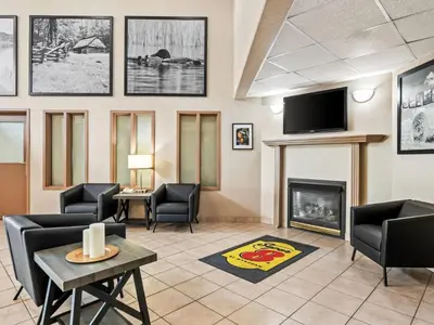 a waiting room with a fireplace and a tv at Super 8 by Wyndham Meadow Lake in Meadow Lake