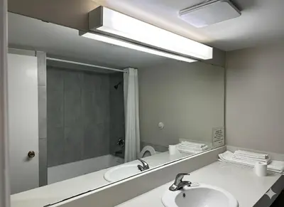a bathroom with a sink and a mirror at Quesnel Inn in Quesnel
