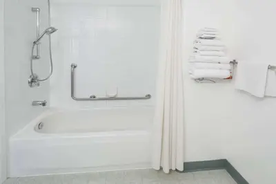 a white bathroom with a tub and towels at Super 8 by Wyndham Three Hills AB in Three Hills