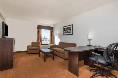 a living room with a desk and a couch at Super 8 by Wyndham Vermilion AB in Vermilion