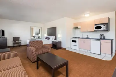 a hotel room with a kitchen and a living room at Super 8 by Wyndham Vermilion AB in Vermilion