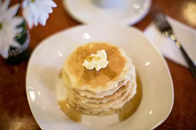 a stack of pancakes on a plate on a table at Service Plus Inns & Suites Drayton Valley in Drayton Valley
