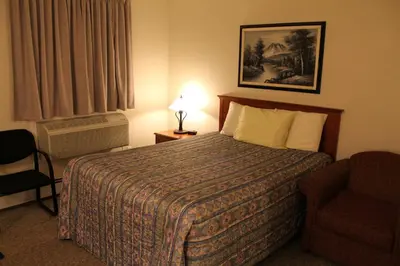 a hotel room with a bed and a chair at Tel Star Motel in Brooks