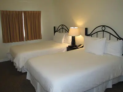 a hotel room with two beds and a lamp at Barclay Hotel in Vancouver