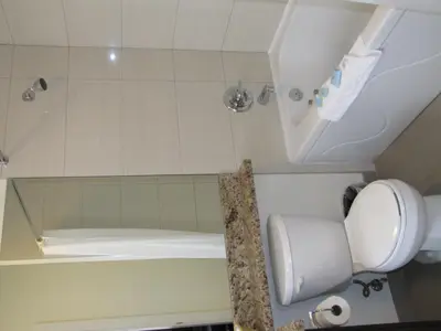 a bathroom with a shower and a toilet and a tub at Barclay Hotel in Vancouver