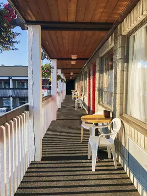 a porch with tables and chairs on a building at Thunderbird Motor Inn in Duncan