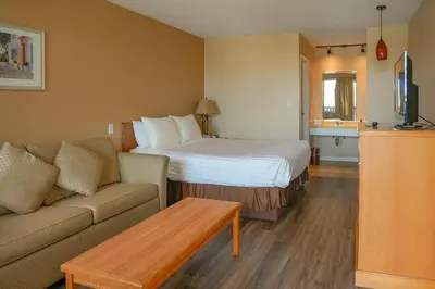 a hotel room with a bed and a couch at Thunderbird Motor Inn in Duncan