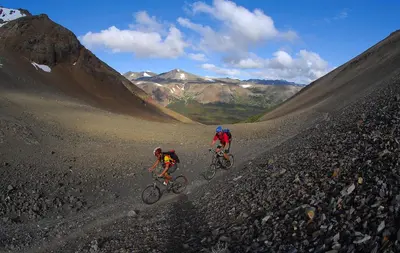 two people riding bikes on a rocky mountain trail at Tyax Lodge & Heliskiing in Gold Bridge