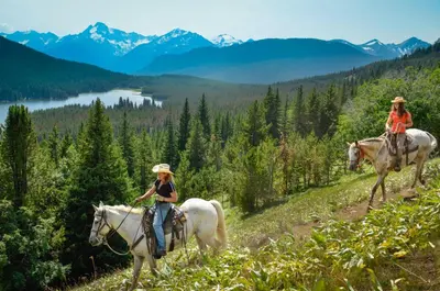 two women riding horses on a mountain trail at Tyax Lodge & Heliskiing in Gold Bridge