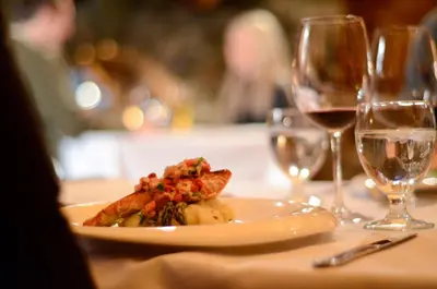 a plate of food on a table with wine glasses at Tyax Lodge & Heliskiing in Gold Bridge