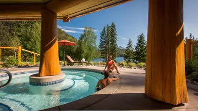 a woman and a dog in a swimming pool at Tyax Lodge & Heliskiing in Gold Bridge