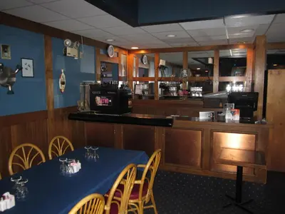 a restaurant with a table and chairs and a bar at Wells Gray Inn in Clearwater
