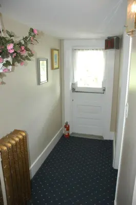 a hallway with a white door and a window at Windsor Guest House in Vancouver