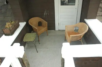 a porch with two chairs and a white door at Windsor Guest House in Vancouver