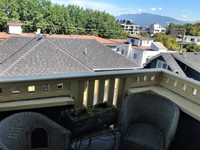 a balcony with two chairs and a roof at Windsor Guest House in Vancouver