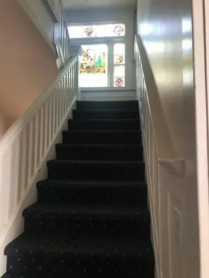 a flight of stairs with a stained glass window at Windsor Guest House in Vancouver