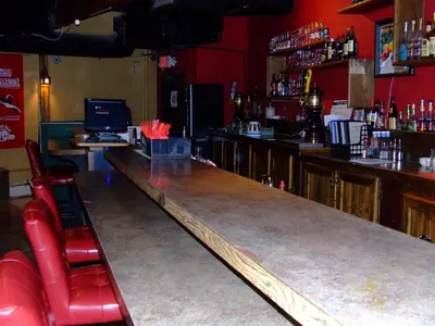 a bar with red chairs and a counter top at The Yukon Inn in Whitehorse