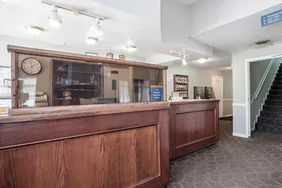 a lobby with a counter with a clock on it at Sandman Inn McBride in McBride