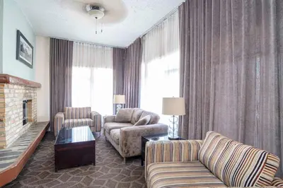 a living room with a couch and a chair and a fireplace at Sandman Inn McBride in McBride