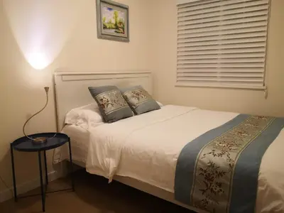 a bedroom with a bed with two pillows and a window at Coquitlam center, 2 bedroom suite, walking to skytrain in Port Coquitlam