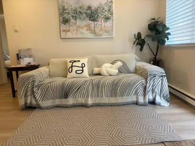 a couch with a teddy bear on it in a living room at Coquitlam center, 2 bedroom suite, walking to skytrain in Port Coquitlam