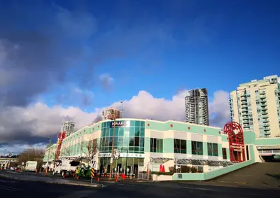 a building on a city street with tall buildings at Coquitlam center, 2 bedroom suite, walking to skytrain in Port Coquitlam